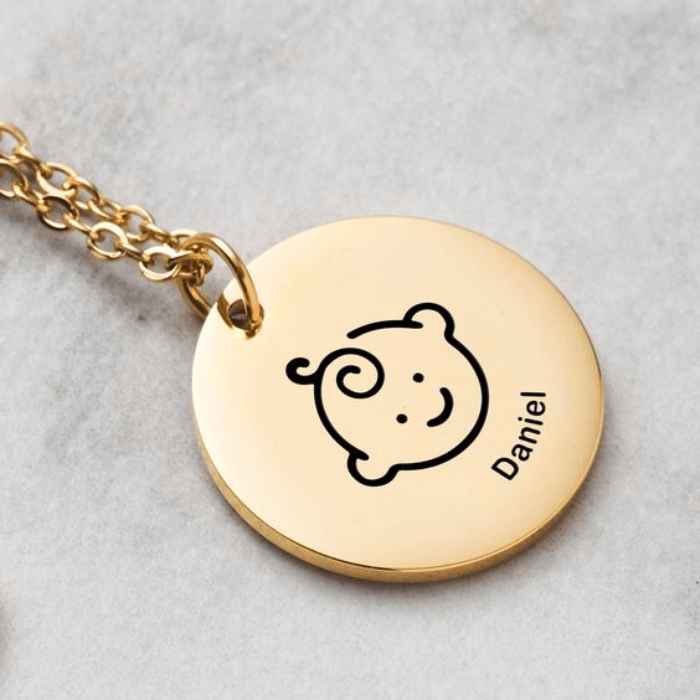 Un pendentif délicat avec une empreinte du bébé ou son nom gravé est un cadeau touchant